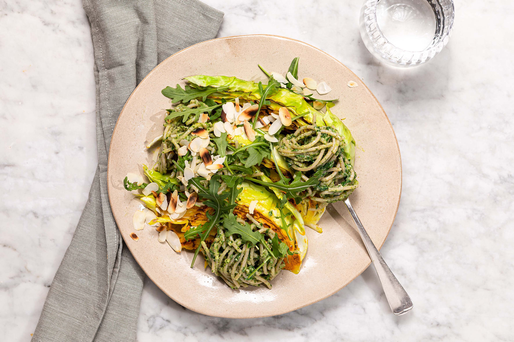 Gegrilde spitskoolsteak met rucola-amandelpesto