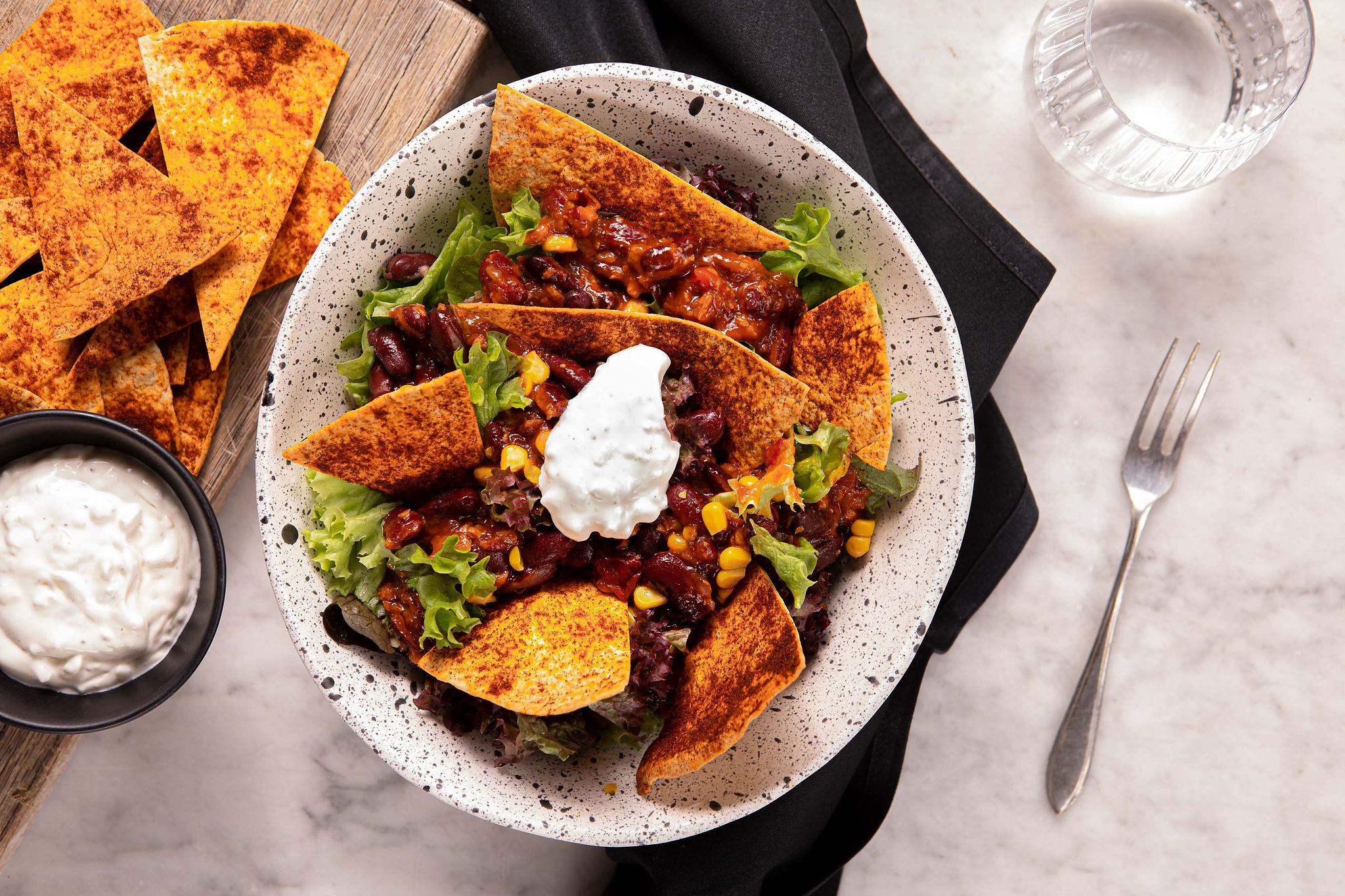 Salade met chili sin carne, knoflookcrème en tortillachips